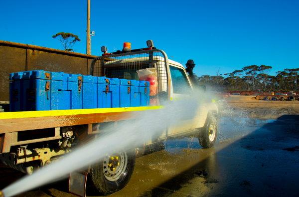 Truck and equipment wash bay — high-pressure spray with vehicle being washed